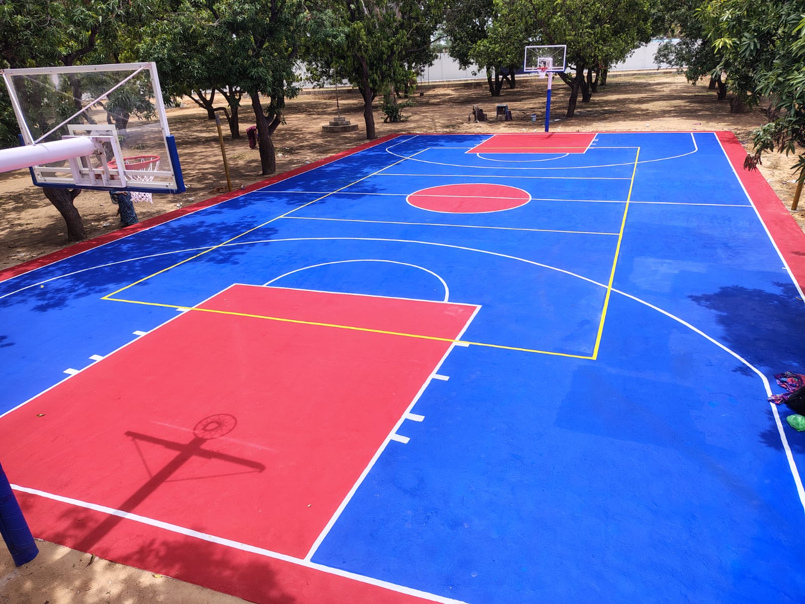 Full-size outdoor basketball court finished in blue and red acrylic